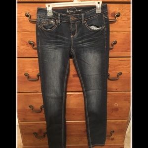 Dark blue jeans w/ decorated pocket.